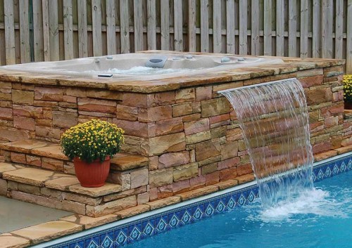 Outdoor hot tub installation with a waterfall.