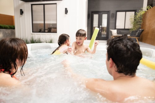 Family playing with hot tub accessories in their spa.