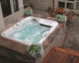 Outdoor hot tub installation surrounded by fall flowers.