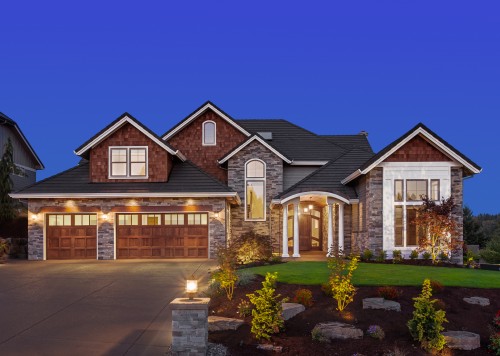 Beautiful house with great curb appeal illuminated at dusk.