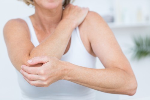 Woman holding her elbow from pain.